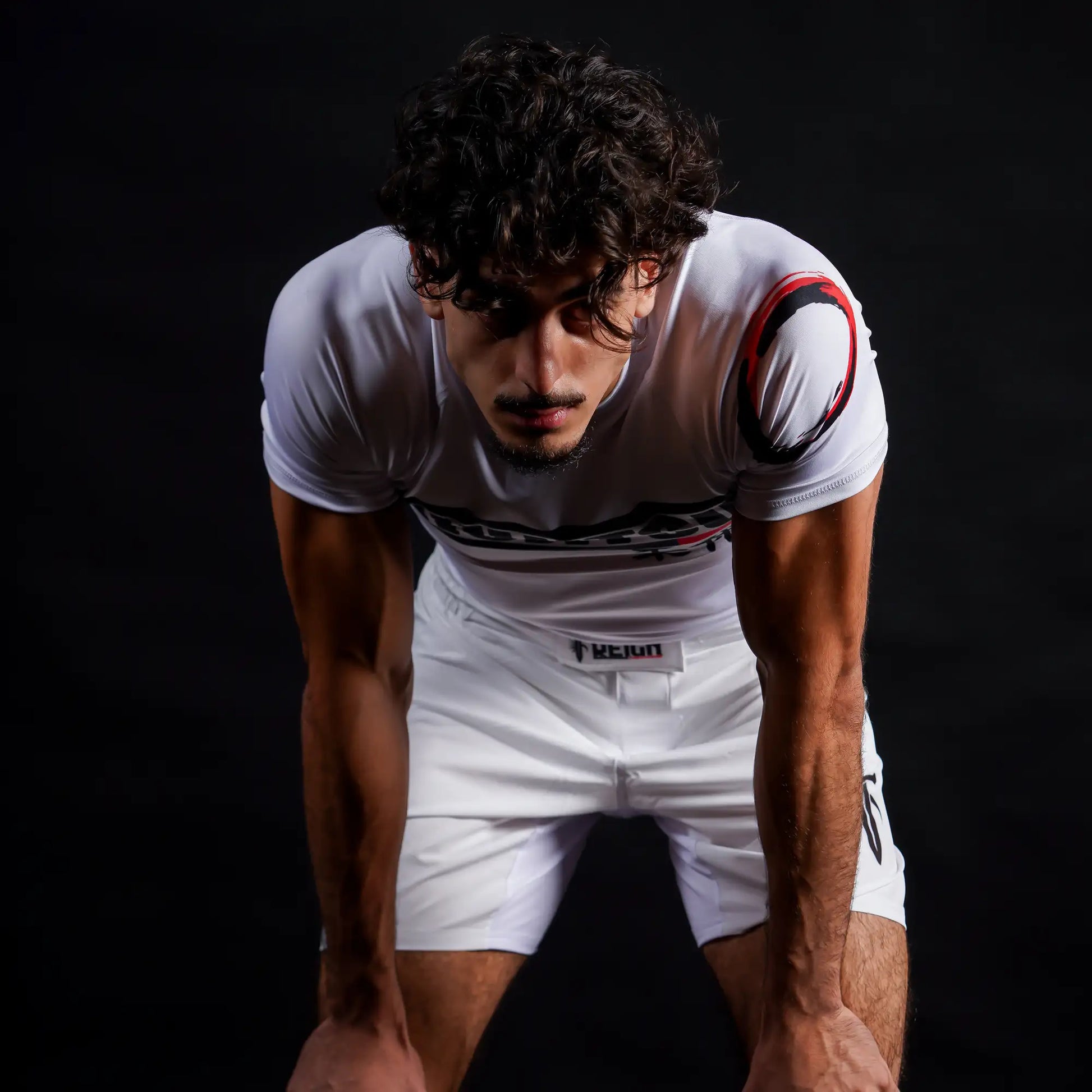 Rashguard Reign Fightwear blanche portée pour un drill de Jiu-Jitsu