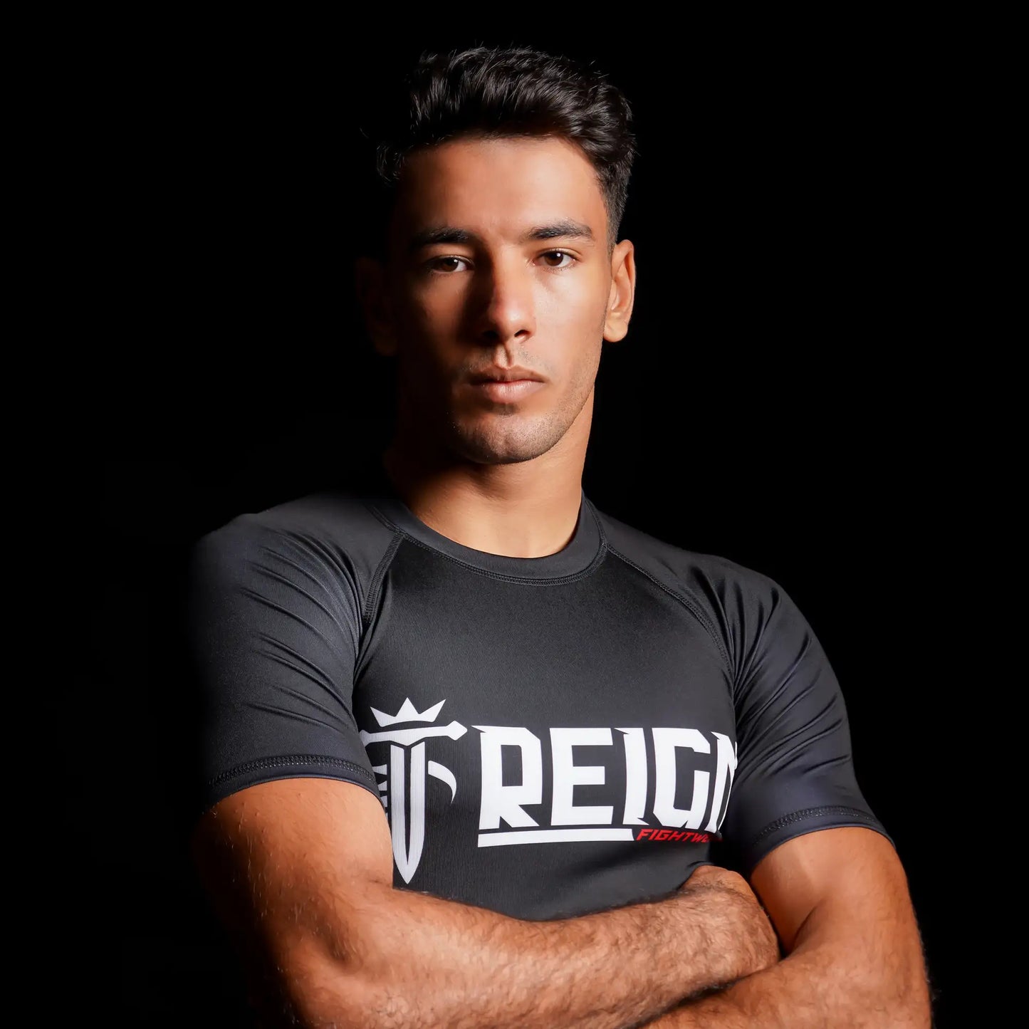 Rashguard Reign Fightwear noire portée par un athlète en séance de grappling